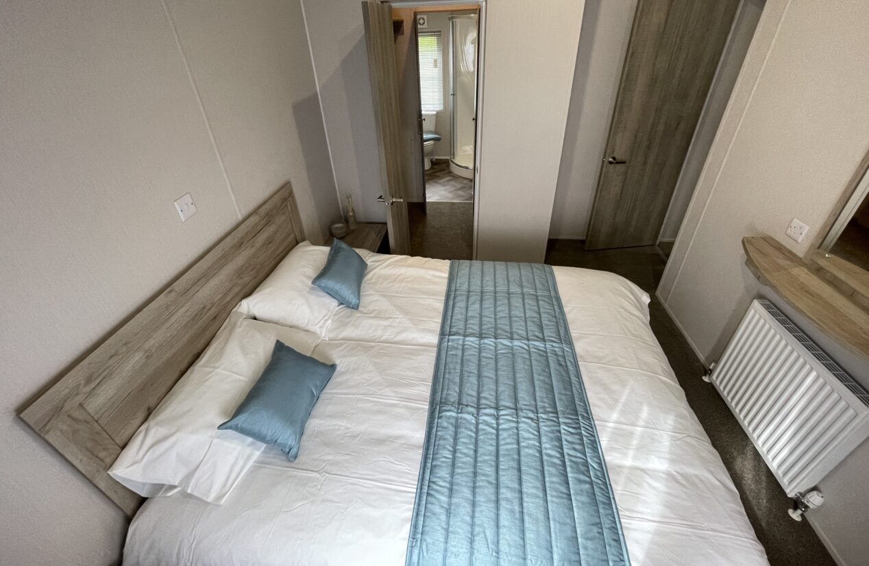 Mester bedroom incorporating the full width of the lodge - walk through wardrobe and en-suite shower room